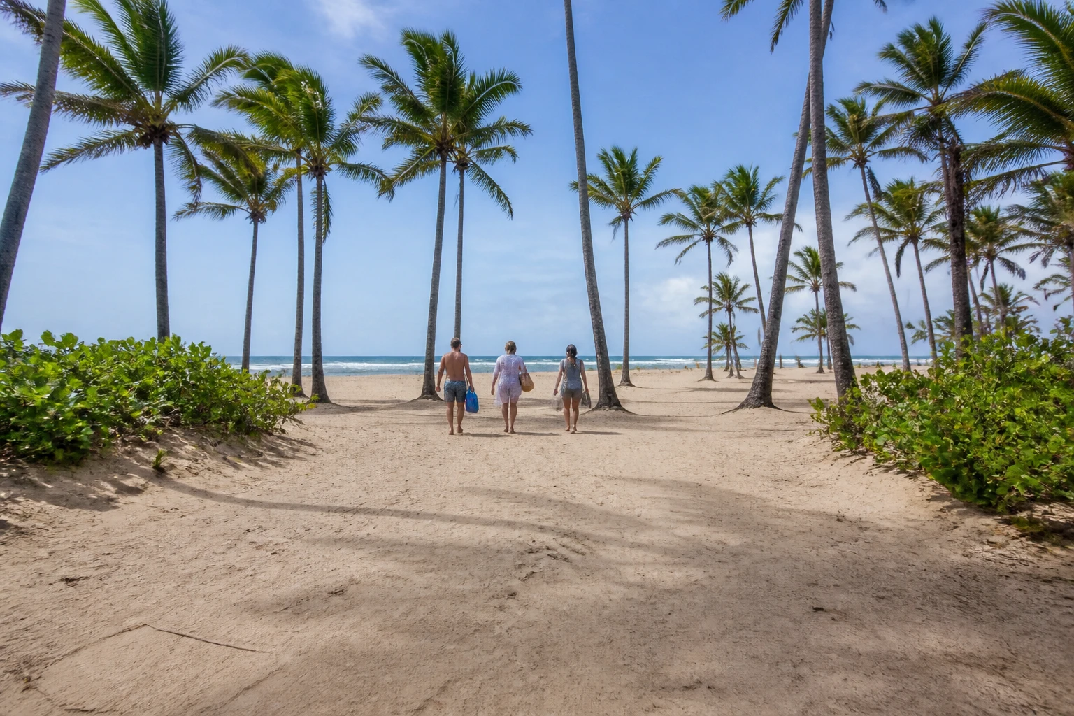 Travelers approaching the open shoreline at Macao Beach