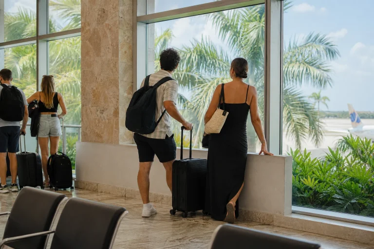 Travelers waiting with carry-on luggage during a Punta Cana airport layover