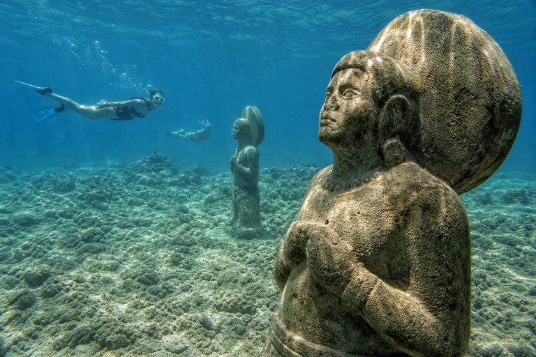 Snorkelers viewing Taíno-inspired underwater sculptures near Punta Cana