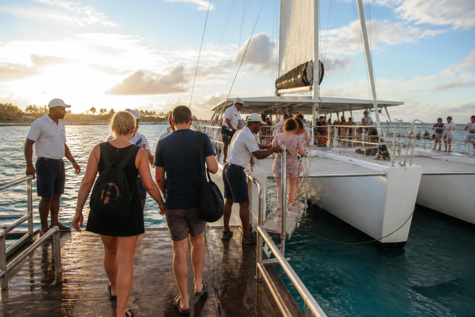 Passengers boarding a catamaran at a tropical dock