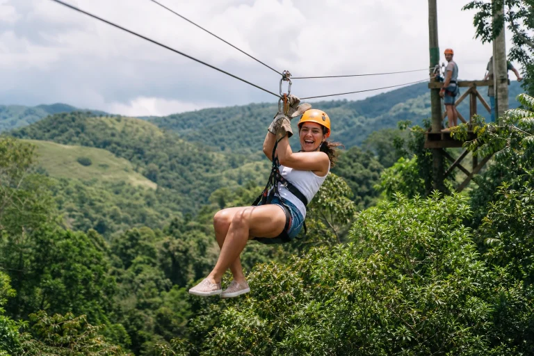 Travelers riding a zipline above a tropical canopy near Punta Cana